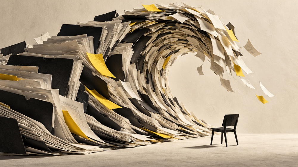 A giant curling wave of paper and file folders looms over a small empty chair